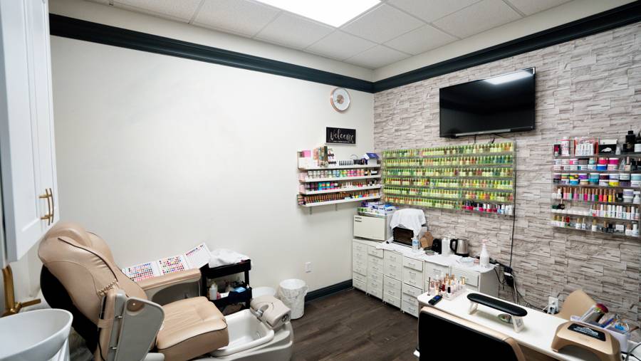 Private nail salon suite with pedicure chair and polish wall in Prosper TX